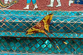 Wat Xieng Thong temple in Luang Prabang, Laos.  La Chapelle Rouge , the Red Chapel. The exterior walls are decorated with colourful mosaics on a pink background with scenes of people daily activities. West wall. 